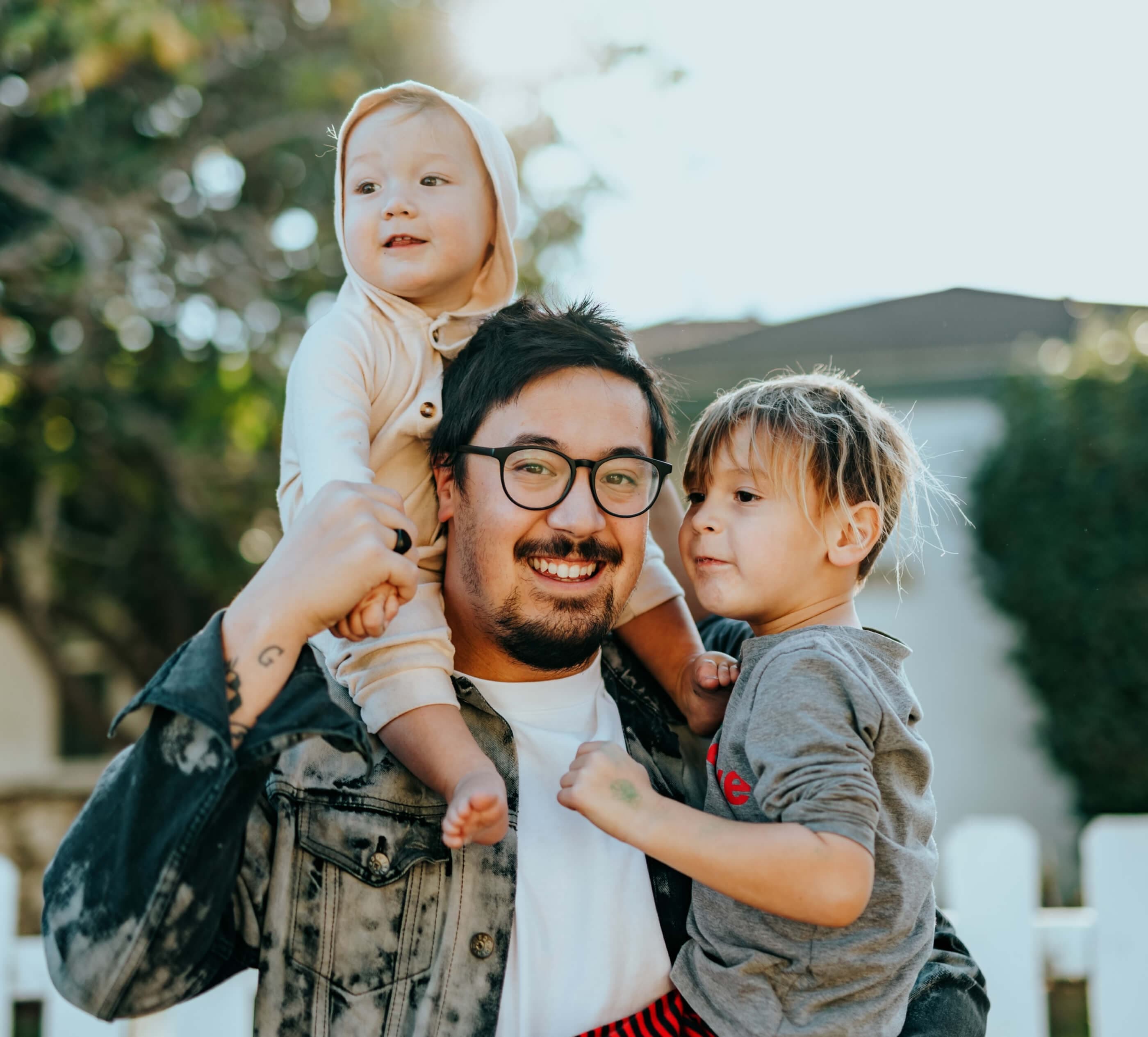 Dad holding his kids and smiling